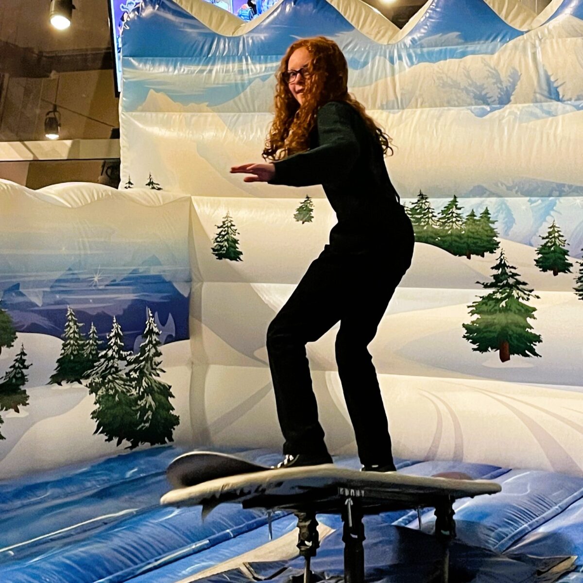 A girl balancing on the snow board machine