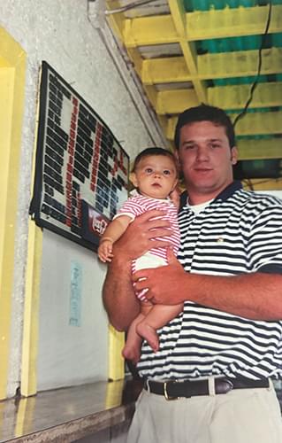 David Bergner holding a little baby in pink clothes.