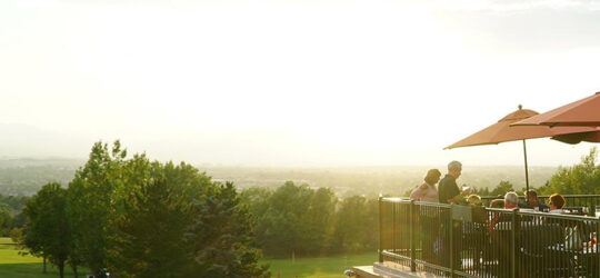 A view of the golf course and club restaurant with the sun rising in the distance.