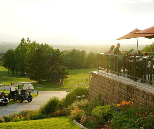 A view of the golf course and club restaurant with the sun rising in the distance.