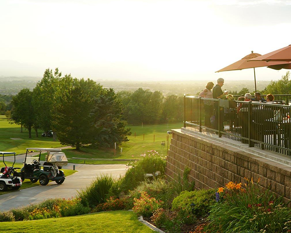 A view of the golf course and club restaurant with the sun rising in the distance.